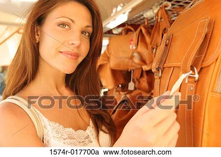 Close-up of a young woman holding the price tag on a bag View Large Photo Image Stock Image - Close-up of a young woman holding the price tag on a bag. Fotosearch