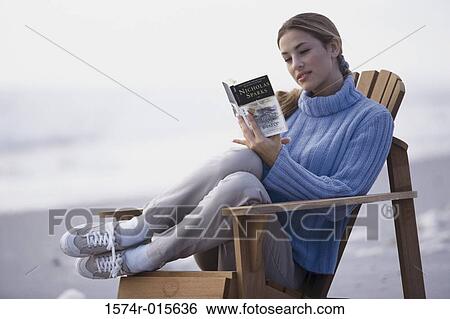 Close-up of a young woman reading a book on the beach View Large Photo Image Stock Photograph - Close-up of a young woman reading a book on the beach. Fotosearch