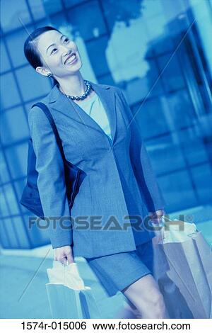 Close-up of a young woman walking with shopping bags View Large Photo Image Stock Photograph - Close-up of a young woman walking with shopping bags. Fotosearch