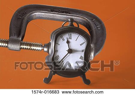 Stock Image - Close-up of an clamp squeezing an alarm clock. Fotosearch
