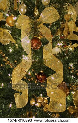 Stock Image - Close-up of Christmas ornaments hanging on a Christmas tree. Fotosearch