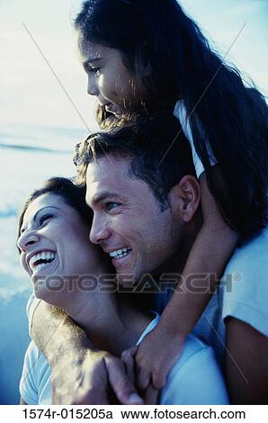 Close-up of parents and their daughter smiling on the beach View Large Photo Image Stock Image - Close-up of parents and their daughter smiling on the beach. Fotosearch