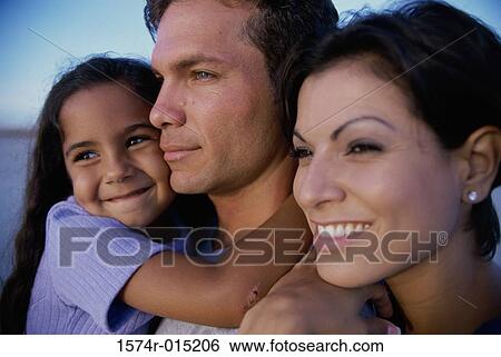 Stock Photograph - Close-up of parents and their daughter smiling. Fotosearch