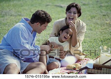 Close-up of parents playing with their daughter in a park View Large Photo Image Stock Image - Close-up of parents playing with their daughter in a park. Fotosearch
