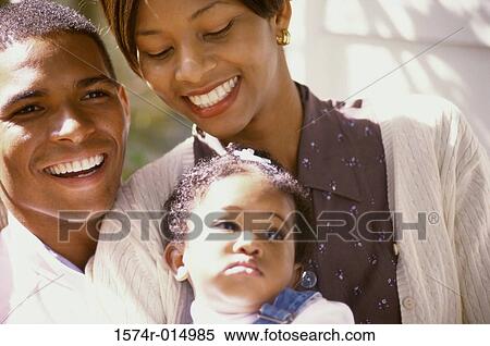 Stock Photography - Close-up of parents smiling at their daughter. Fotosearch