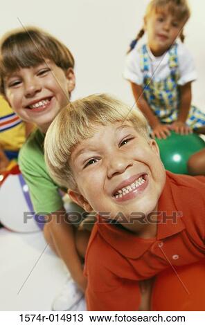 Close-up of two boys and a girl smiling View Large Photo Image Stock Image - Close-up of two boys and a girl smiling. Fotosearch