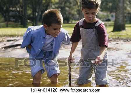 Close-up of two boys standing in water View Large Photo Image Stock Photo - Close-up of two boys standing in water. Fotosearch