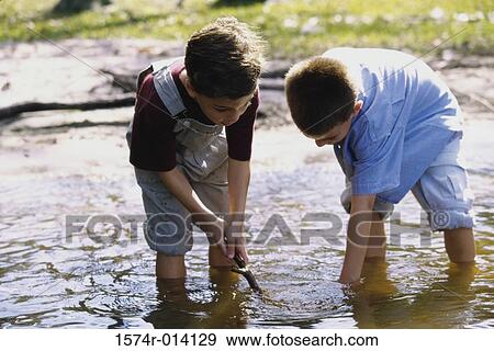 Close-up of two boys standing in water View Large Photo Image Stock Photo - Close-up of two boys standing in water. Fotosearch