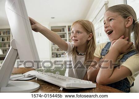 Close-up of two girls pointing to a computer monitor View Large Photo Image Stock Image - Close-up of two girls pointing to a computer monitor. Fotosearch