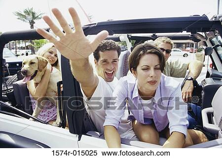 Stock Photography - Close-up of two young couples sitting in a jeep. Fotosearch