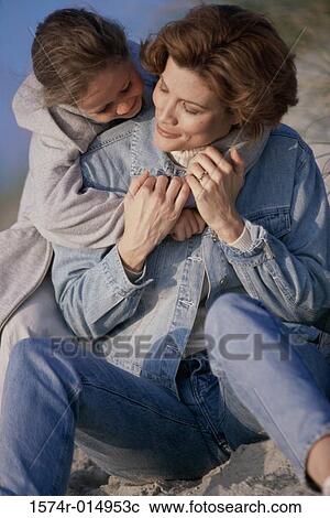 Stock Image - Daughter hugging her mother from behind. Fotosearch