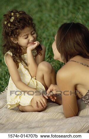 Daughter sitting with her mother in a park View Large Photo Image Stock Image - Daughter sitting with her mother in a park. Fotosearch