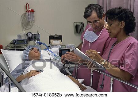 Doctor attending to a patient with a nurse View Large Photo Image Stock Image - Doctor attending to a patient with a nurse. Fotosearch