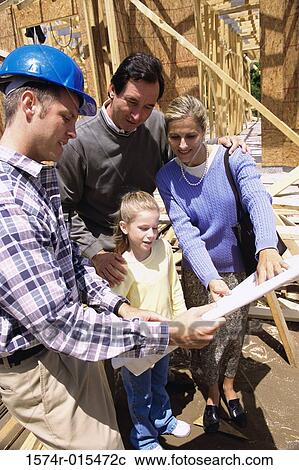 Family standing at a construction site with a worker holding blueprints View Large Photo Image Stock Image - Family standing at a construction site with a worker holding blueprints. Fotosearch