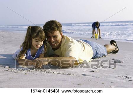 Father and his daughter writing in sand on the beach View Large Photo Image Stock Image - Father and his daughter writing in sand on the beach. Fotosearch