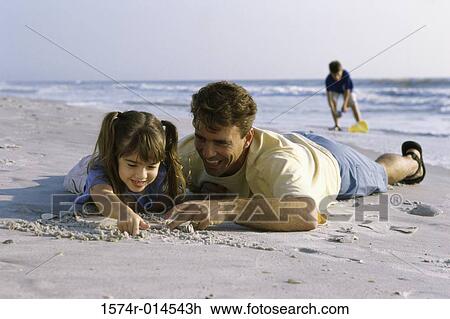 Father and his daughter writing in sand on the beach View Large Photo Image Stock Image - Father and his daughter writing in sand on the beach. Fotosearch