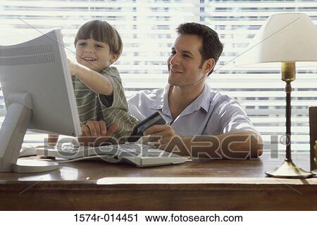 Father and son sitting in front of a computer View Large Photo Image Stock Image - Father and son sitting in front of a computer. Fotosearch