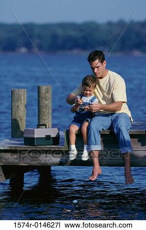 Father and son sitting on a pier fishing View Large Photo Image Stock Image - Father and son sitting on a pier fishing. Fotosearch