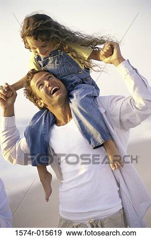 Stock Photo - Father carrying his daughter on his shoulders. Fotosearch