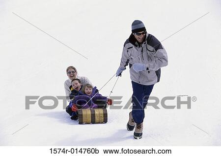 Father pulling his family on a sled View Large Photo Image Stock Image - Father pulling his family on a sled. Fotosearch