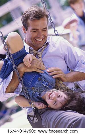 Father sitting on a swing with his daughter View Large Photo Image Stock Image - Father sitting on a swing with his daughter. Fotosearch