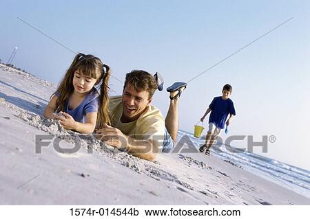 Stock Image - Father with his children on the beach. Fotosearch