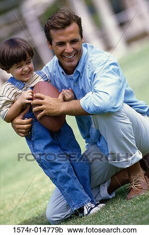 Stock Image - Father with his daughter holding a football. Fotosearch