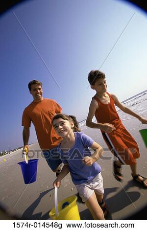 Father with his son and daughter running on the beach View Large Photo Image Stock Image - Father with his son and daughter running on the beach. Fotosearch