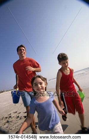 Father with his son and daughter running on the beach View Large Photo Image Stock Image - Father with his son and daughter running on the beach. Fotosearch