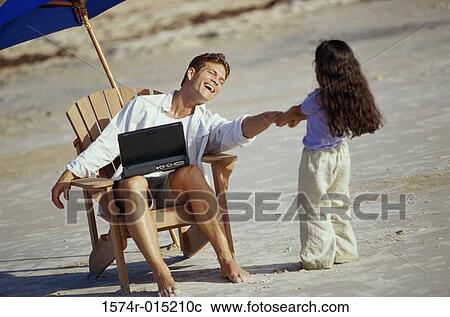 Father working on a laptop with his daughter pulling his hand on the beach View Large Photo Image Stock Image - Father working on a laptop with his daughter pulling his hand on the beach. Fotosearch