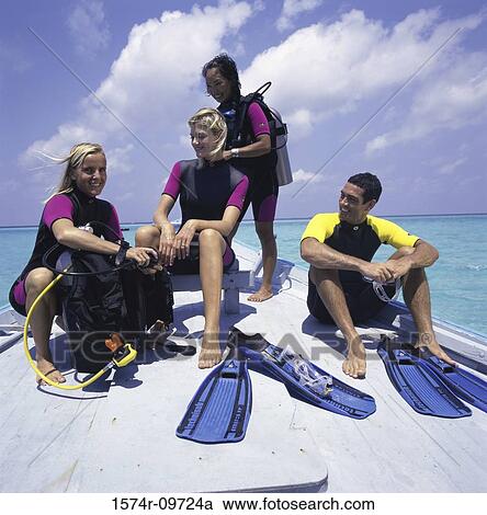 Four people in scuba gear sitting on the bow of a boat View Large Photo Image Stock Image - Four people in scuba gear sitting on the bow of a boat. Fotosearch
