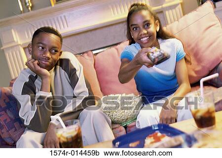 Girl watching television with her brother looking at her View Large Photo Image Stock Image - Girl watching television with her brother looking at her. Fotosearch