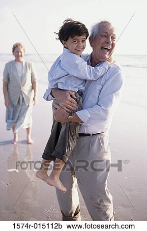 Grandfather carrying his grandson on the beach View Large Photo Image Stock Image - Grandfather carrying his grandson on the beach. Fotosearch