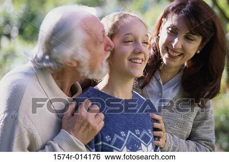 Grandfather kissing his granddaughter with her mother standing beside her View Large Photo Image Stock Photograph - Grandfather kissing his granddaughter with her mother standing beside her. Fotosearch