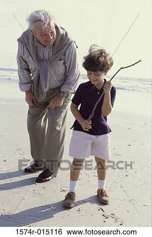 Grandfather playing with his grandson on the beach View Large Photo Image Stock Photograph - Grandfather playing with his grandson on the beach. Fotosearch
