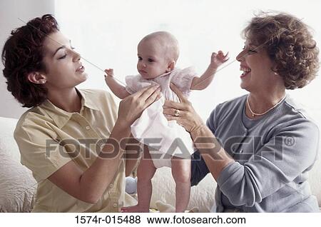 Grandmother smiling with her daughter and granddaughter View Large Photo Image Stock Photo - Grandmother smiling with her daughter and granddaughter. Fotosearch