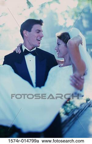 Groom carrying his bride View Large Photo Image Stock Image - Groom carrying his bride. Fotosearch