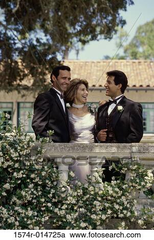 Stock Image - Groom standing with his parents. Fotosearch