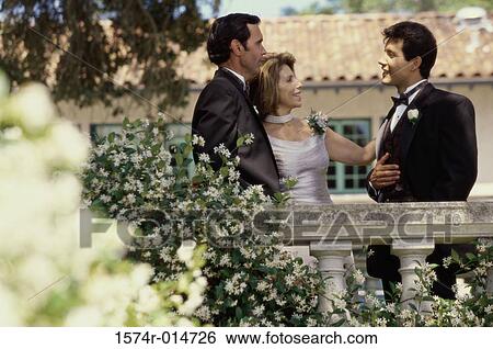 Stock Photograph - Groom standing with his parents. Fotosearch