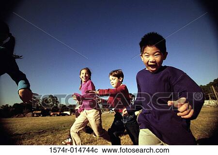 Group of children running on a lawn View Large Photo Image Stock Image - Group of children running on a lawn. Fotosearch