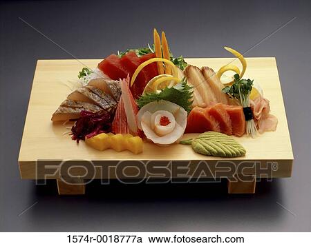 Stock Image - High angle of sashimi and wasabi on a cutting board. Fotosearch