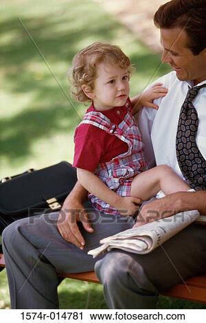 High angle view of a boy sitting on his father's lap View Large Photo Image Stock Image - High angle view of a boy sitting on his father's lap. Fotosearch
