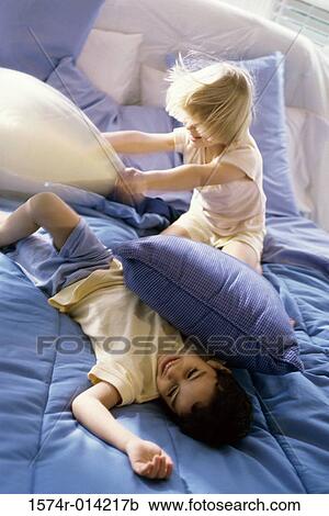 High angle view of a brother and sister having a pillow fight View Large Photo Image Stock Image - High angle view of a brother and sister having a pillow fight. Fotosearch