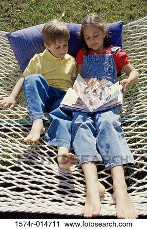 High angle view of a brother and sister reading a book in a hammock View Large Photo Image Stock Image - High angle view of a brother and sister reading a book in a hammock. Fotosearch