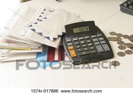 High angle view of a calculator with envelopes and coins on a table View Large Photo Image Stock Photograph - High angle view of a calculator with envelopes and coins on a table. Fotosearch