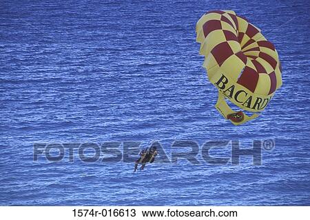 High angle view of a couple enjoying parasailing View Large Photo Image Stock Image - High angle view of a couple enjoying parasailing. Fotosearch