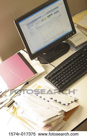 Stock Photography - High angle view of a desktop pc with a stack of envelopes on a table. Fotosearch