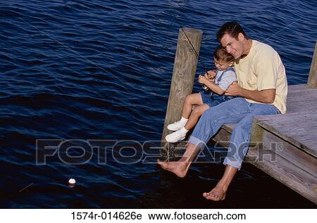High angle view of a father teaching his son to fish View Large Photo Image Stock Image - High angle view of a father teaching his son to fish. Fotosearch