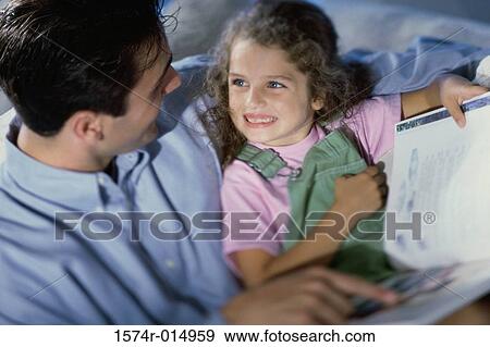 Stock Photo - High angle view of a father teaching his daughter. Fotosearch