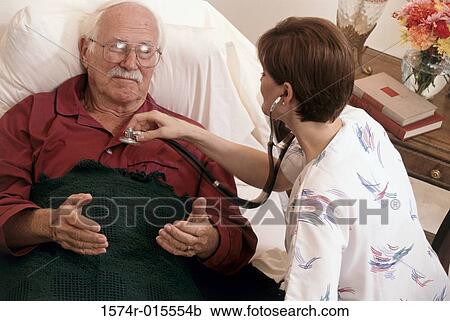 Stock Image - High angle view of a female nurse examining a patient. Fotosearch